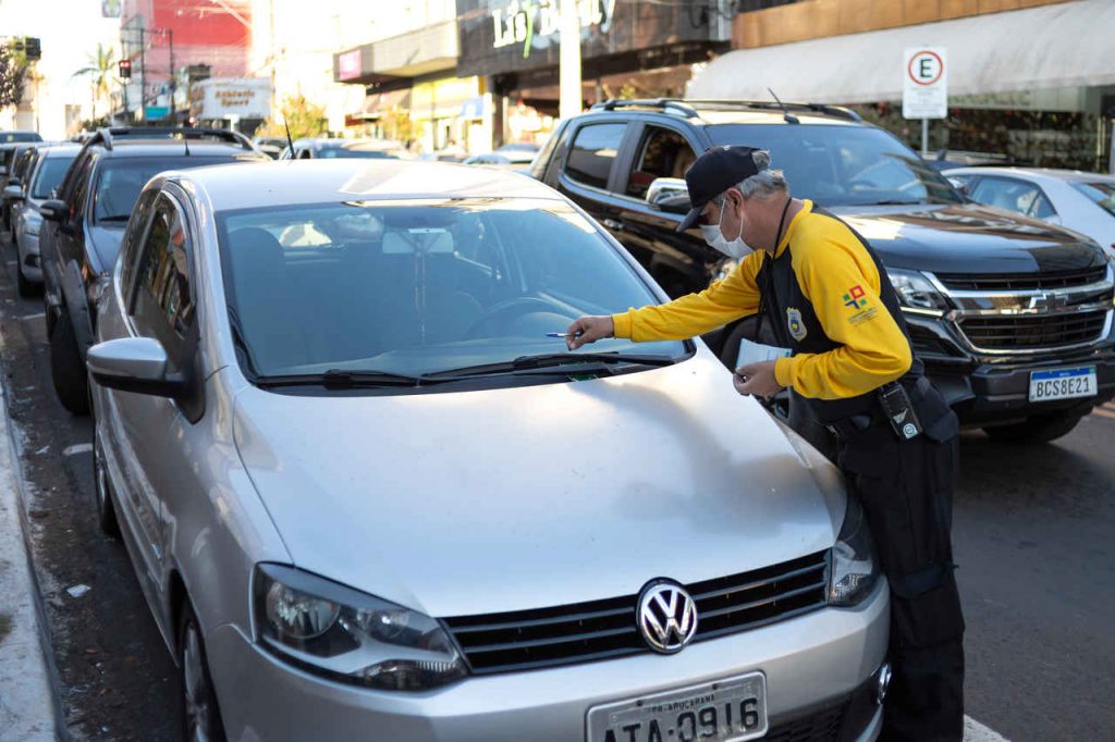 agente de transito multa motorista por estacionamento irregular