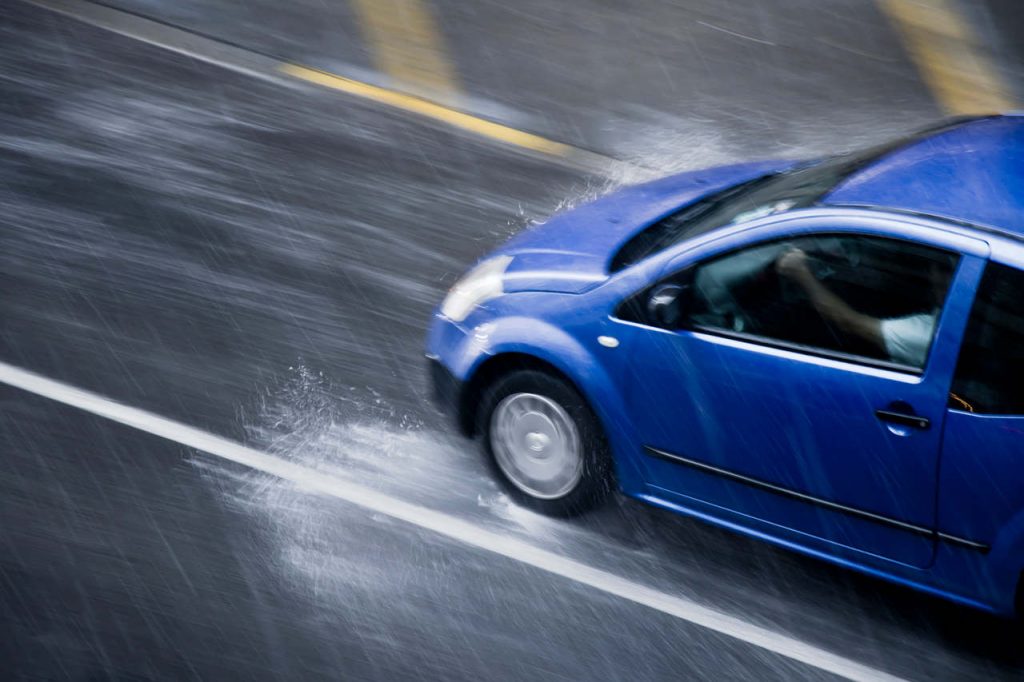 carro azul rápido na chuva